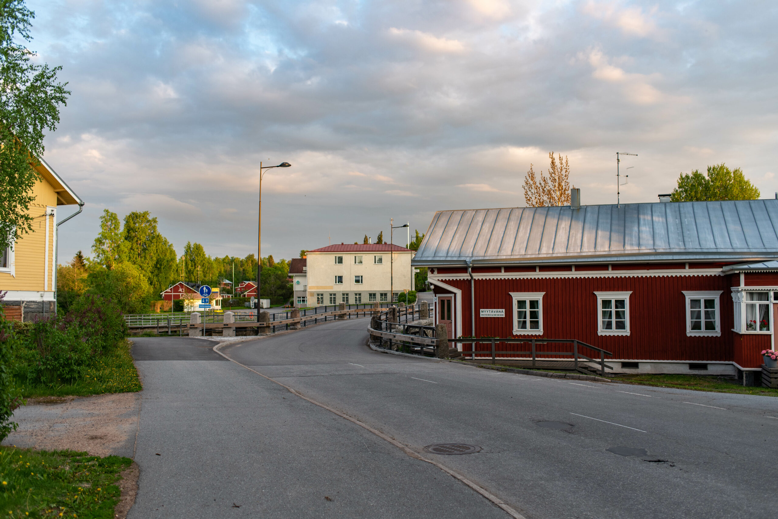 kuva punaisesta ja keltaisesta rakennuksesta, jonka välissä kulkee Pomarkun kivisilta
