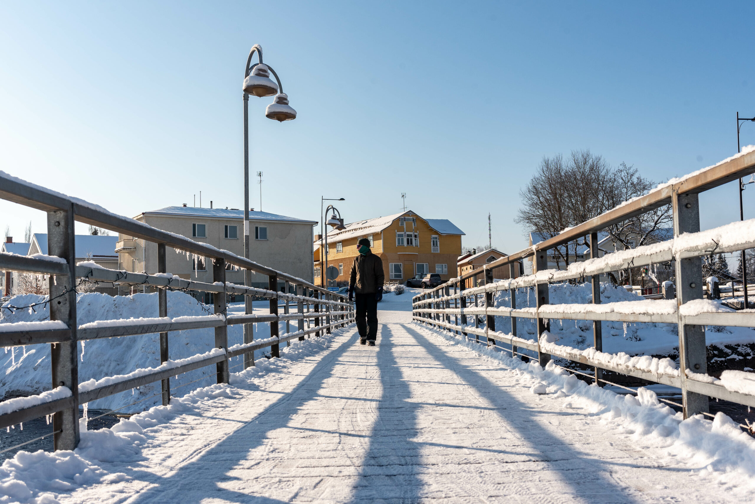 Lunta, kävelysilta, henkilö ja rakennuksia.