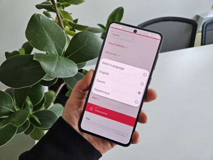 Käsi, kännykkä, kukkanen.