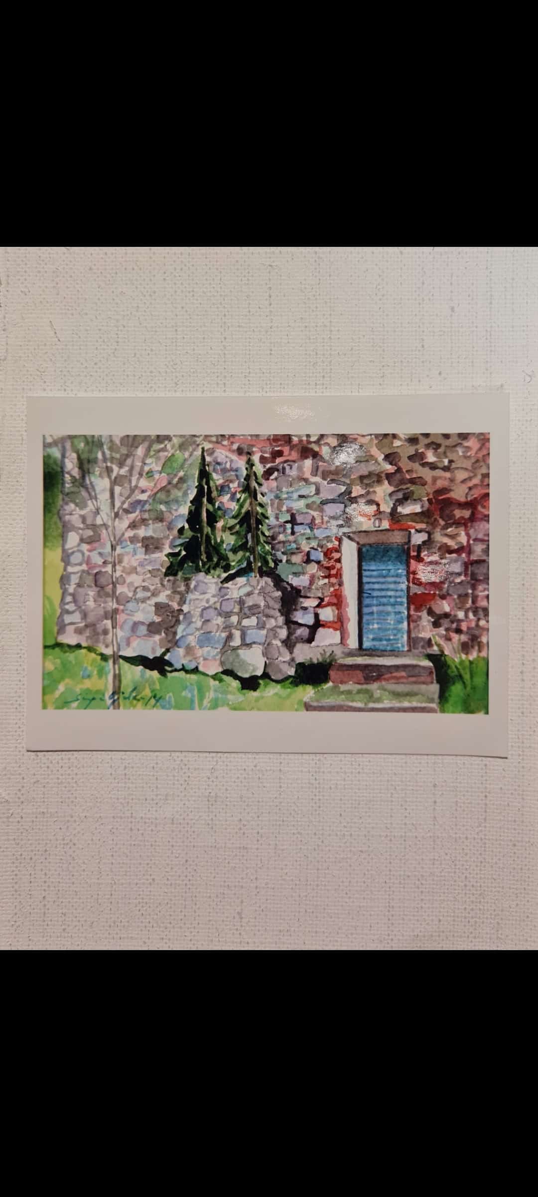 "Akvarelli Kivilinnasta ennen remonttia. Harmaita kiviä seinässä jossa sininen ovi. Vihreää ruohoa etualalla."