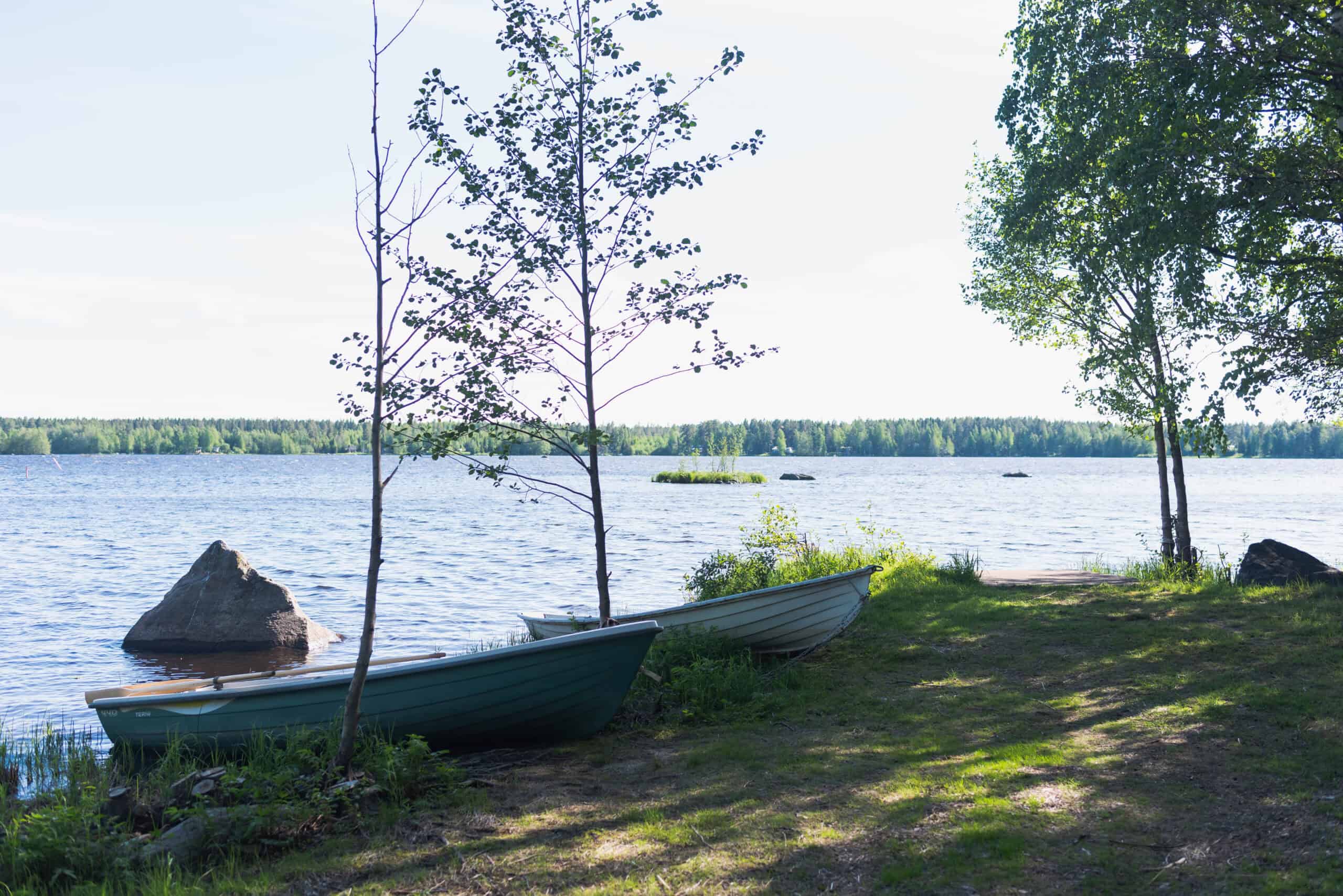 "Vettä, ranta, soutuveneitä, puita."